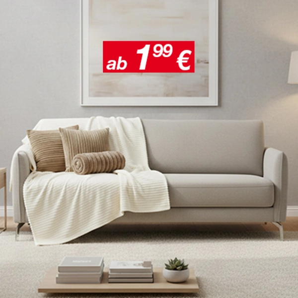 Helles Wohnzimmer mit grauem Sofa, Kissen und Decke, Beistelltisch und Stehlampe.