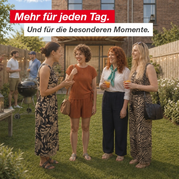 Gruppe von Menschen unterhält sich und genießt Getränke in einem Hinterhofgarten mit Holzzaun und Lichterketten.
