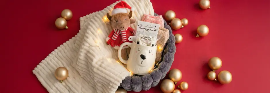 Eine gemütliche Wohnzimmerszene mit einer Frau in einem grauen Kleid, die auf einem Sofa sitzt, einem hölzernen Couchtisch mit Blumen und einem Getränk sowie Plüschtieren in der Nähe.