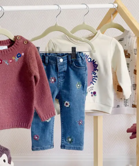 Eine süße Jeanshose hängt an einem Kleiderbügel