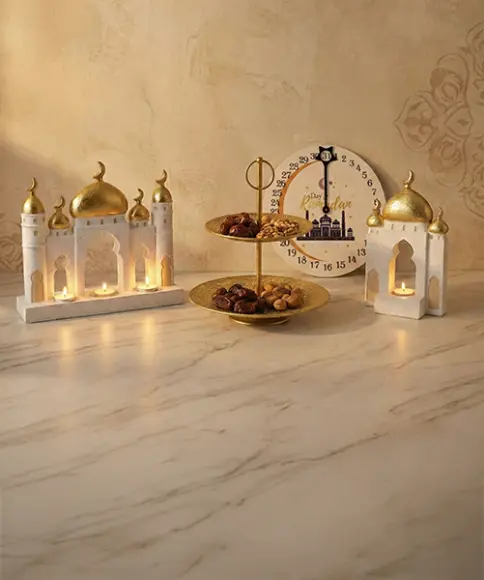 Ramadan-Deko mit goldenen Laternen, Etageren und Datten auf Marmoroberfläche.