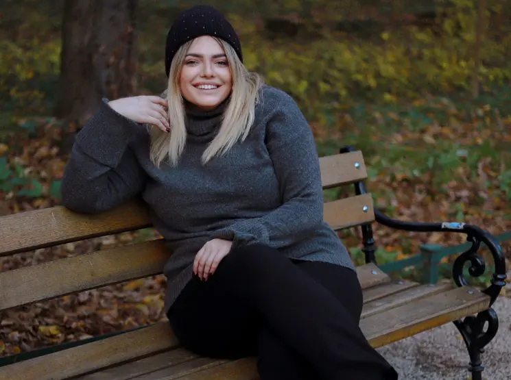 Eine Frau sitzt auf einer Bank im Park und genießt die Umgebung