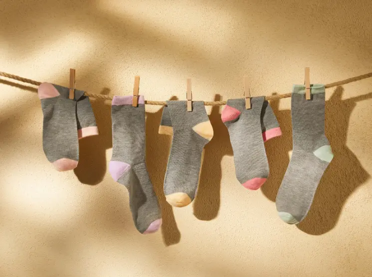 An einer Wäscheleine hängen graue Socken