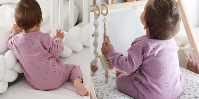 Ein Kleinkind in einem rosafarbenen Strampler mit Herzchenmuster spielt ruhig in einem Kinderbett und erkundet mit Neugier und Freude die Spielsachen. Ein Kleinkind in einem rosafarbenen Strampler mit Herzchenmuster spielt ruhig in einem Kinderbett und erkundet mit Neugier und Freude die Spielsachen.