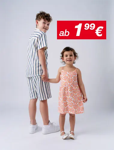 Ein Junge in einem gestreiften Outfit und ein Mädchen in einem geblümten Kleid halten sich lächelnd an den Händen, vor einem schlichten weißen Hintergrund.