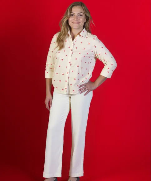 Eine oder mehrere Frauen präsentieren stilvolle Outfits vor einem leuchtend roten Hintergrund – darunter gemusterte Kleider, bedruckte Oberteile, Hosen und gestreifte Röcke.