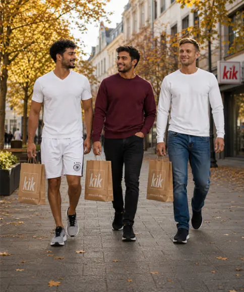 Drei Männer in sportlichen und herbstlichen Freizeitoutfits mit KiK Einkaufstüten beim Stadtbummel