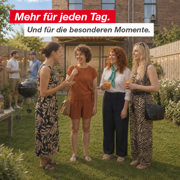Gruppe von Menschen unterhält sich und genießt Getränke in einem Hinterhofgarten mit Holzzaun und Lichterketten.