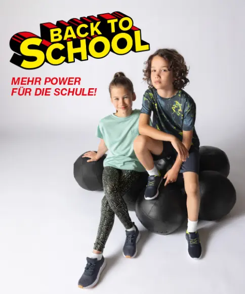 Zwei Kinder sitzen auf großen schwarzen Gymnastikbällen und präsentieren farbenfrohe Sportbekleidung.