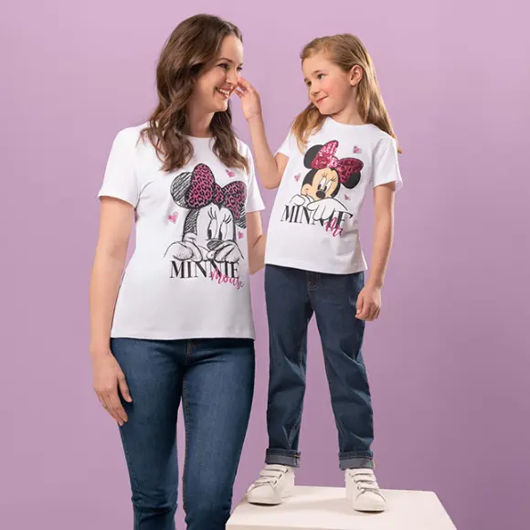 Eine Mutter und eine Tochter tragen eine Jeanshose und das gleiche Minnie Maus T-Shirt