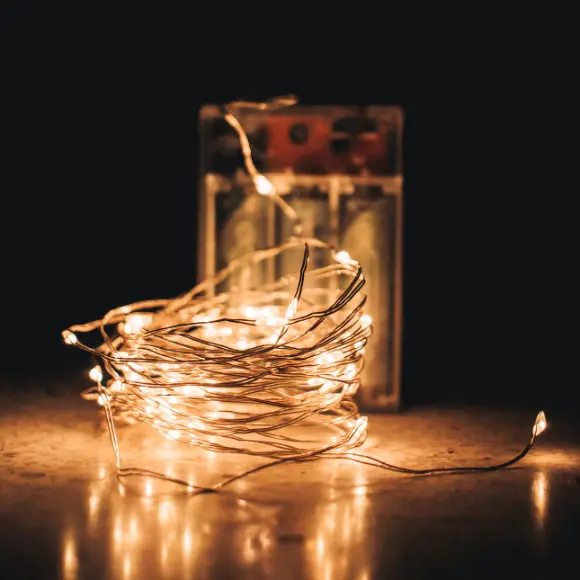 Eine Lichterkette liegt dekorativ auf einem Tisch.