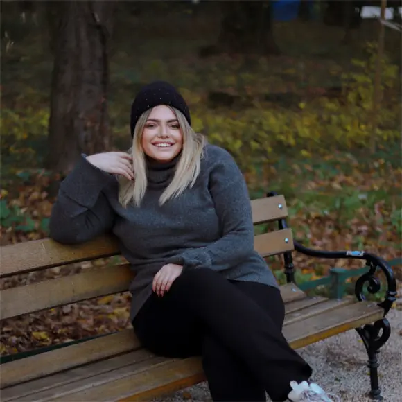 Eine Frau sitzt auf einer Bank im Park und genießt die Umgebung