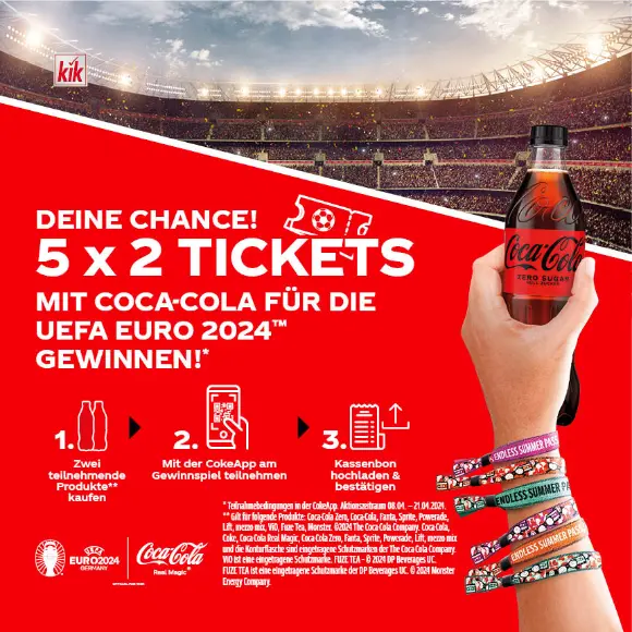In einem vollen Stadion wird eine Coca-Cola-Flasche zelebrierend hochgehalten.