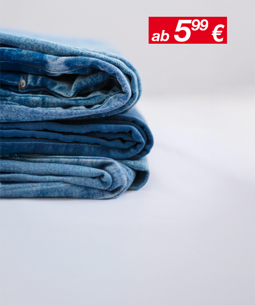 Drei ordentlich gefaltete Paar Blue Jeans, die übereinander gestapelt sind.