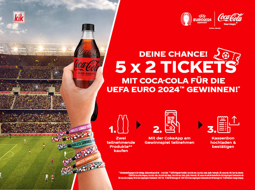 In einem vollen Stadion wird eine Coca-Cola-Flasche zelebrierend hochgehalten.