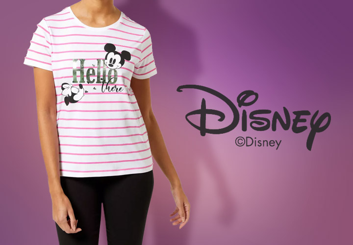 Eine Frau trägt ein rosa-weiß gestreiftes Disney-T-Shirt mit Mickey Mouse und dem Text „Hello there“ vor einem lila Hintergrund.